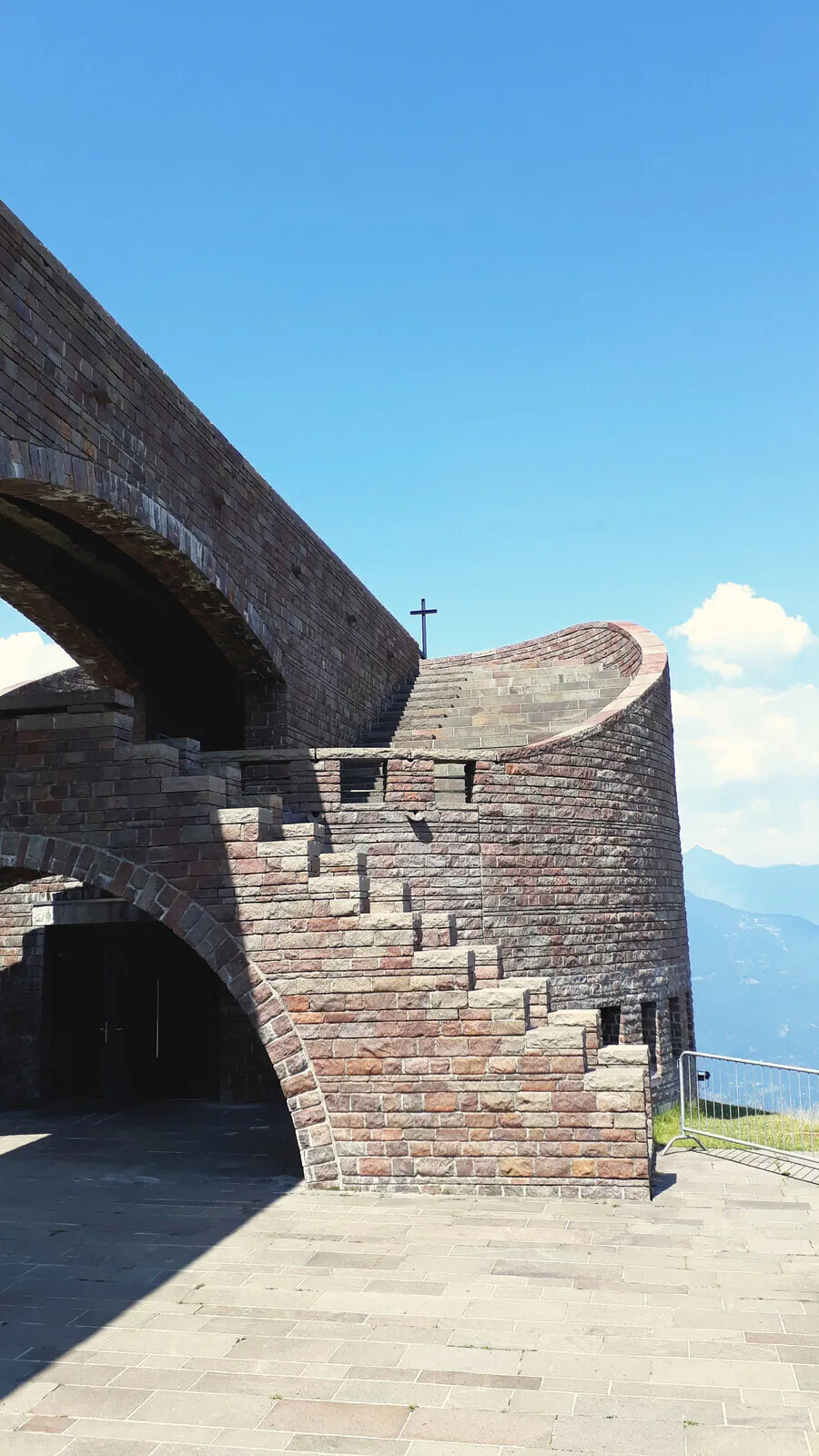 A curved brick church against the sky in Ticino.
