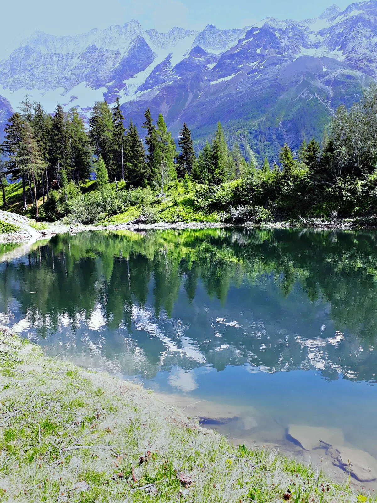 An alpine lake holding the reflection of the peaks above it.